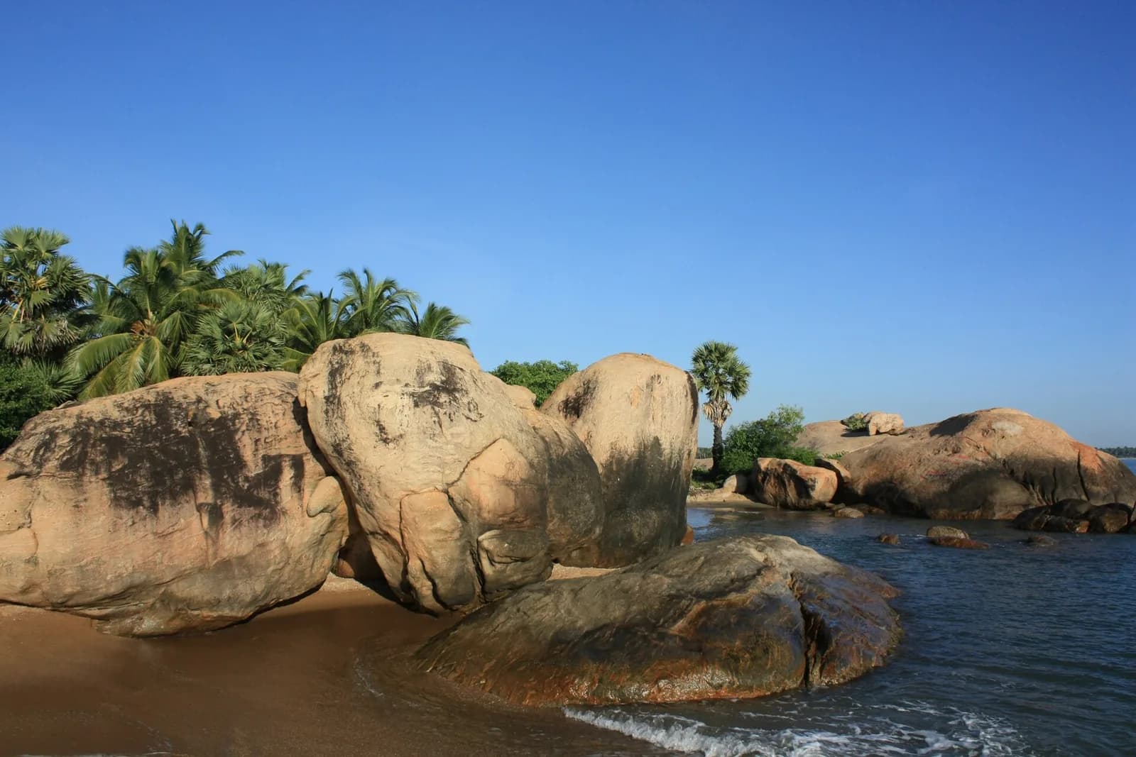 Calm shallow turquoise waters and white sandy crescent of Pasikudah Bay in Eastern Sri Lanka