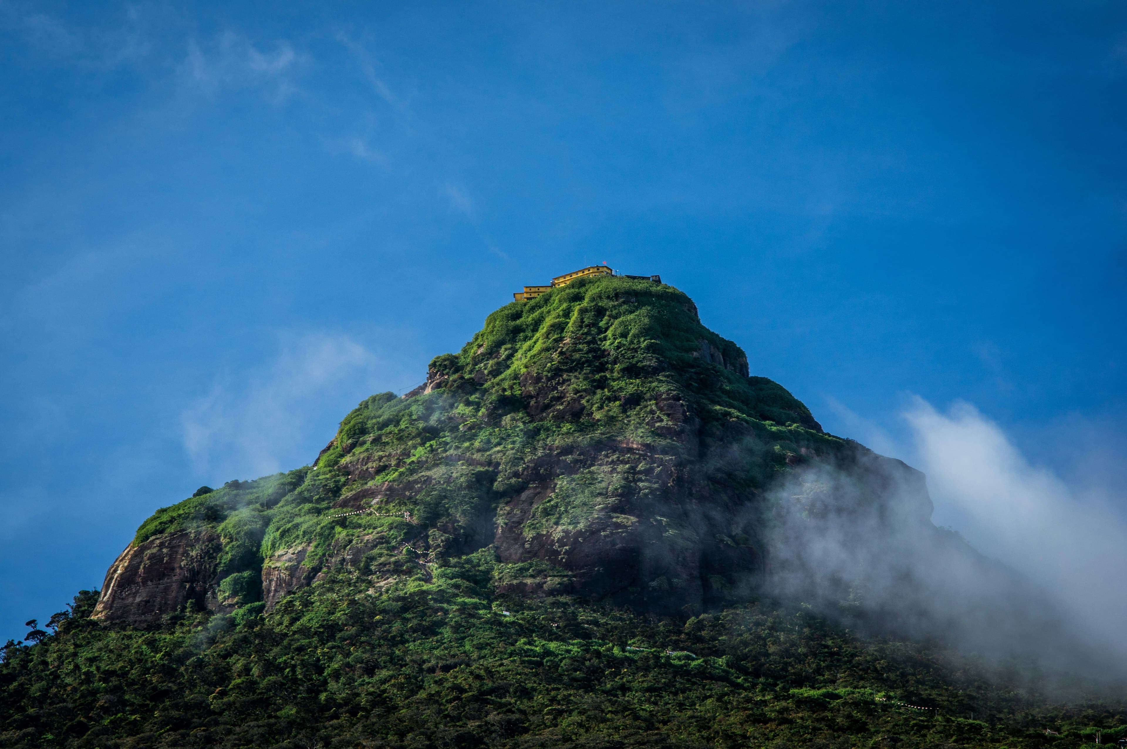 Spectacular morning sun rays illuminating the mountain slopes of Adam's Peak.