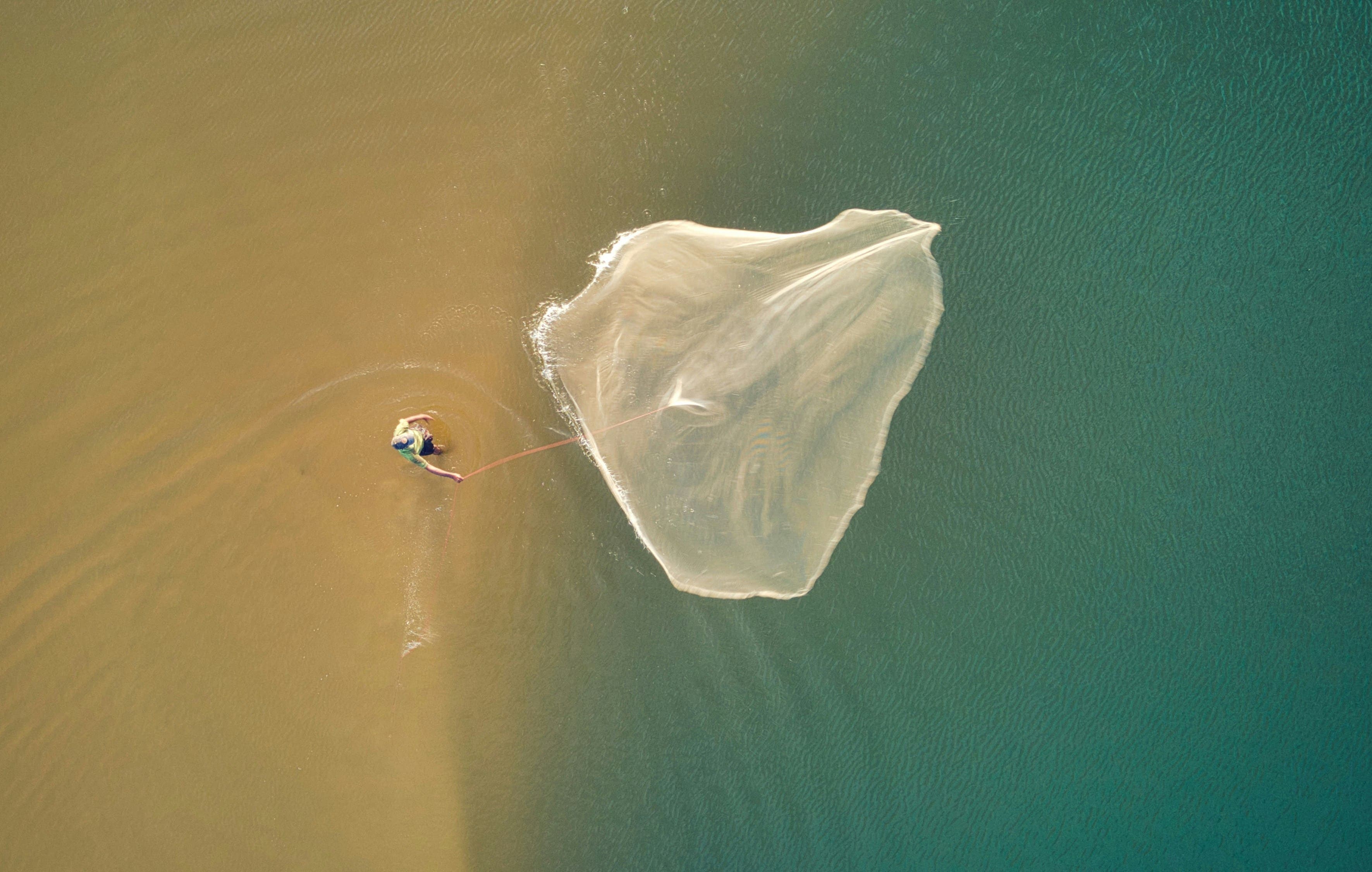 Local fishermen tending their nets along the golden shoreline.