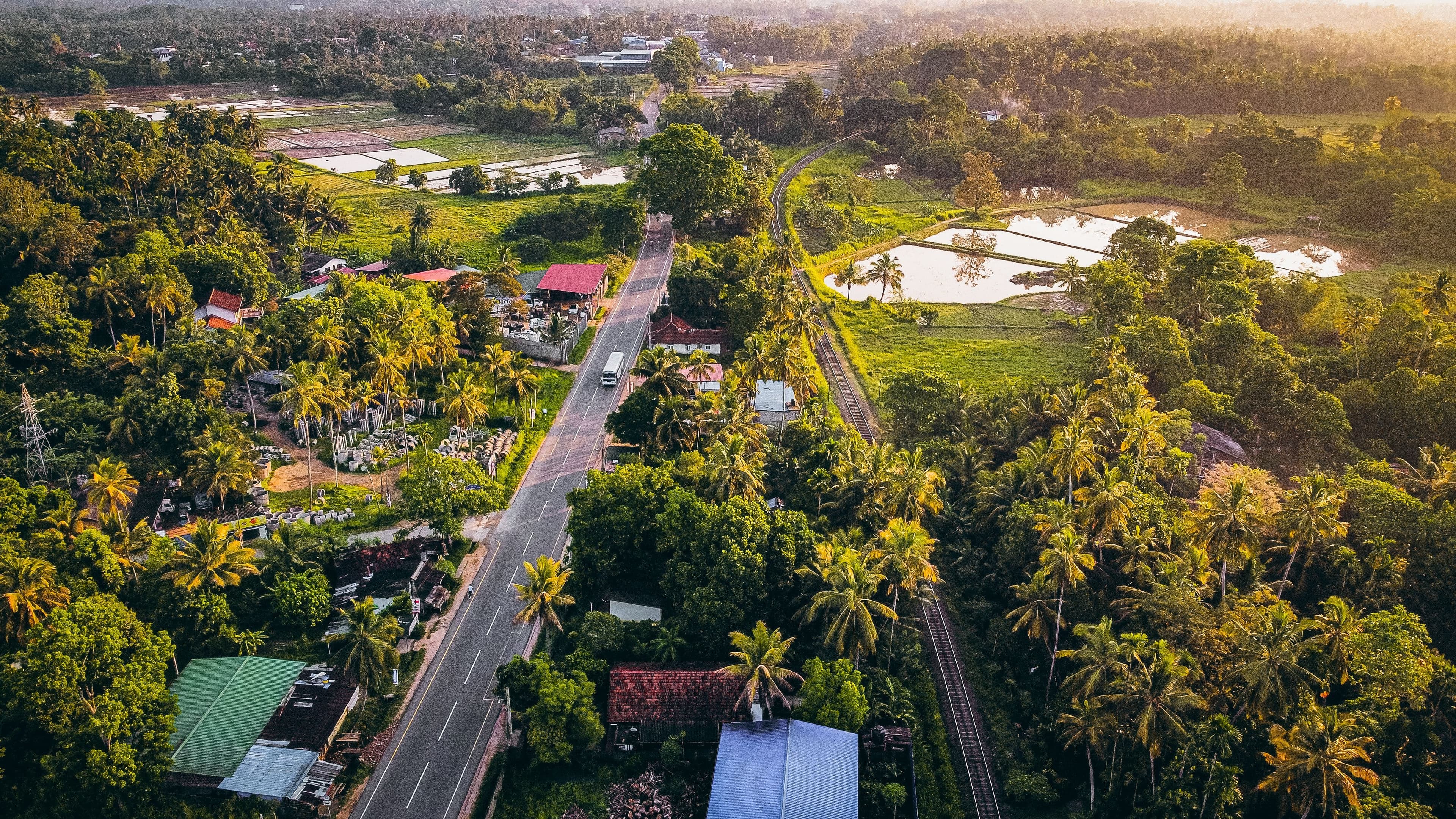 Bird's-eye view across lush tropical forests and undulating mountain terrain.